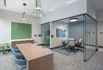 a conference room with glass walls and a table and chairs at Inspire West Town, CHICAGO, 60642